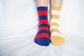 Women`s legs in socks colors alternating, side stand on white fabric floor. Royalty Free Stock Photo