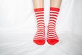 Women`s legs in socks colors alternating, side stand on white fabric floor. Royalty Free Stock Photo