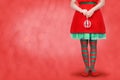 Women`s legs in striped stockings stand on a red Christmas background Royalty Free Stock Photo