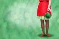 Women`s legs in striped stockings stand on a red Christmas background Royalty Free Stock Photo