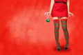 Women`s legs in striped stockings stand on a red Christmas background Royalty Free Stock Photo