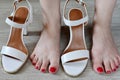 Women's legs and white sandals