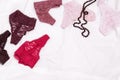 Women`s lingerie on white bed sheet. Many different lace bikini panties and black beads