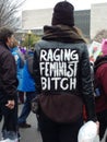 Women`s March on Washington DC, Woman Walking Through the Crowd Wearing a Jacket Labeled `Raging Feminist` Royalty Free Stock Photo