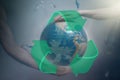 Women`s and men`s hands support the globe of planet Earth with sign of recycle. Around the flying plastic debris. Royalty Free Stock Photo