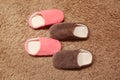 Women`s and men`s slippers standing on the carpet. Two pairs of house shoes Royalty Free Stock Photo