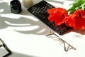 Women`s office desk .Female workspace with laptop, flowers red tulips,