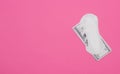 Women`s pads and money dollars on a pink background, the cost of hygiene products, copy space, spending Royalty Free Stock Photo