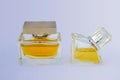 Women`s perfume bottles, half filled with golden liquid. Transparent glass containers with chrome lids