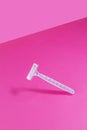 Women`s plastic razor on a bright pink isothermal background.