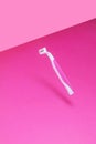 Women`s plastic razor on a bright pink isothermal background.