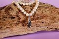 Women's platinum pendant with a black and white diamonds on a preciouse pearls necklace