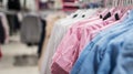 Women`s shirts and blouses on hangers in a clothing store