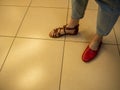 In a women's shoe store, a girl chooses and tries on beautiful and comfortable summer shoes. Close-up. Royalty Free Stock Photo