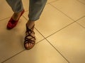 In a women's shoe store, a girl chooses and tries on summer shoes Royalty Free Stock Photo