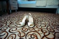 Women`s shoes on the colorful carpet in the hotel. Beige wedding shoes on the floor, close up Royalty Free Stock Photo