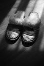 Women`s slippers with a sheepskin on a wooden floor. BW