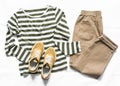 Women`s slouchy pants, a long sleeve striped cotton t-shirt and suede sneakers on a light background. top view. Comfortable
