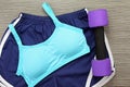 Women`s sports bra and Dumbbell. Fitness wear and equipment.