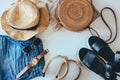 Women`s summer clothes collage on white, flat lay. Woven sandals, rattan bag, hat, watch, shorts, sunglasses top view Royalty Free Stock Photo