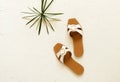 Women`s summer shoes sandals and tropical leaf on white vintage background Royalty Free Stock Photo