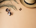 Women`s summer straw hat, sunglasses and jewelry on a beige background. Copy space