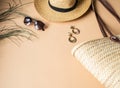 Women`s summer straw hat, wicker bag, sunglasses and jewelry on a beige background. Copy space