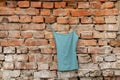 women's underwear blue t-shirt hangs on hangers on a brick old wall at home on the street, fashion