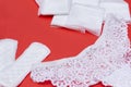 1 women`s white lace panties, multiple sanitary pads, daily pads on red