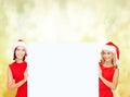 Women in santa helper hats with blank white board Royalty Free Stock Photo