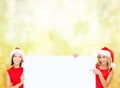 Women in santa helper hats with blank white board Royalty Free Stock Photo