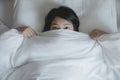 Woman with scare and panic while lying down under the blanket in bedroom,Nightmare or bad dream Royalty Free Stock Photo