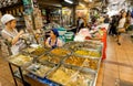 Women sell asian fast-food with meat inside the market with delicacies and farming products Royalty Free Stock Photo