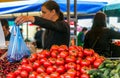 Women sell on the market ripe vegetables, onions, peppers, cucumber, greens