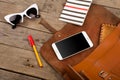 women set with bag, smart phone, sunglasses, notepad, pen and purse on brown wooden desk Royalty Free Stock Photo