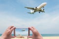 The women shooting image with smart phone on blue sea and white