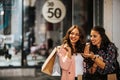 Two happy women with shopping bags enjoying in shopping, having fun in the city Royalty Free Stock Photo