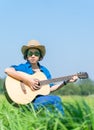 Women short hair wear hat and sunglasses sit playing guitar in g Royalty Free Stock Photo