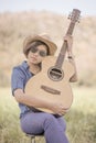 Women short hair wear hat and sunglasses sit playing guitar in g Royalty Free Stock Photo