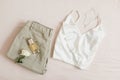 Women silk lingerie and jeans and accessories on beige background top view, flatlay