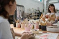 Women sit at the table and process clay blanks Royalty Free Stock Photo