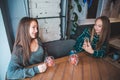 Women sitting in cafe. girlfriends taking picture on phone while drinking warm fruit tea Royalty Free Stock Photo