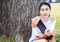 Women sitting near big tree and drawing in the park. Royalty Free Stock Photo