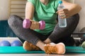 women sitting and holding dumbbell and water in fitness room,beautiful young woman working out with dumbbells Royalty Free Stock Photo