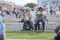 Women sitting outdoors at a reading activity, using masks and keeping distance