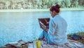 Women sitting a relax River side in the park. sitting working with a notebook and drinking coffee. in the holiday