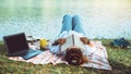 Women sitting a relax River side in the park. sitting working with a notebook and drinking coffee. in the holiday