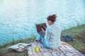 Women sitting a relax River side in the park. sitting working with a notebook and drinking coffee. in the holiday