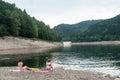 Women sitting in suit swim in border lake