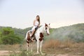 Women on skirt dress Riding Horses On field landscape Against forest. Royalty Free Stock Photo